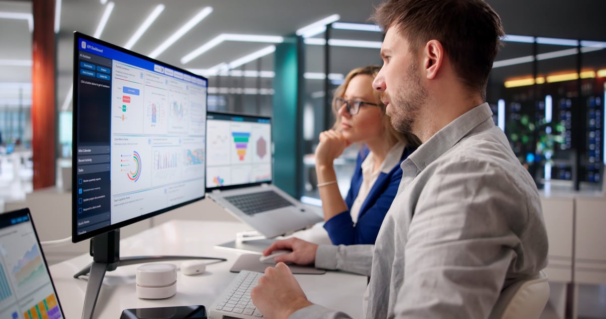 Business professionals analyzing marketing KPIs on a laptop
